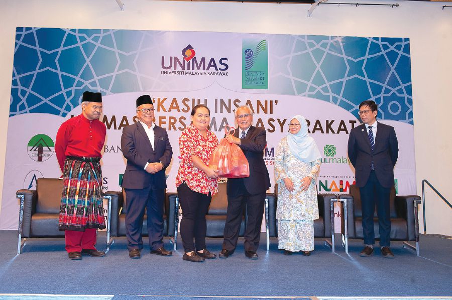 Unimas pro-chancellor Datuk Patinggi Tan Sri Dr Alfred Jabu Numpang (third from right) handing a ‘Box of Love’ to a recipient from the Iban ethnic group for the Gawai celebration.