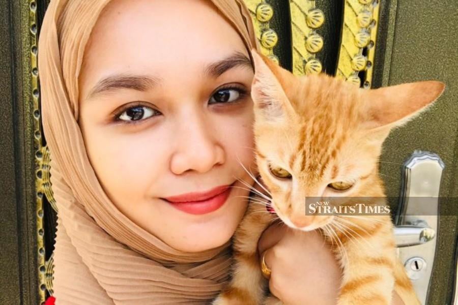 Her name is Mayamin Husna Hisham and no, she was not "catnapping" an orange cat. NSTP/ Courtesy of Pic courtesy of Mayamin Husna Hisham