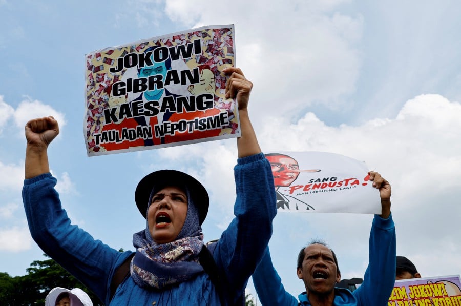 JAKARTA: An anti-government protester holds a placard denouncing Indonesia's outgoing President Joko Widodo during a rally demanding for a fair election, outside the Indonesian parliament in Jakarta, Indonesia, on Monday (Feb 12). — Reuters File Pic