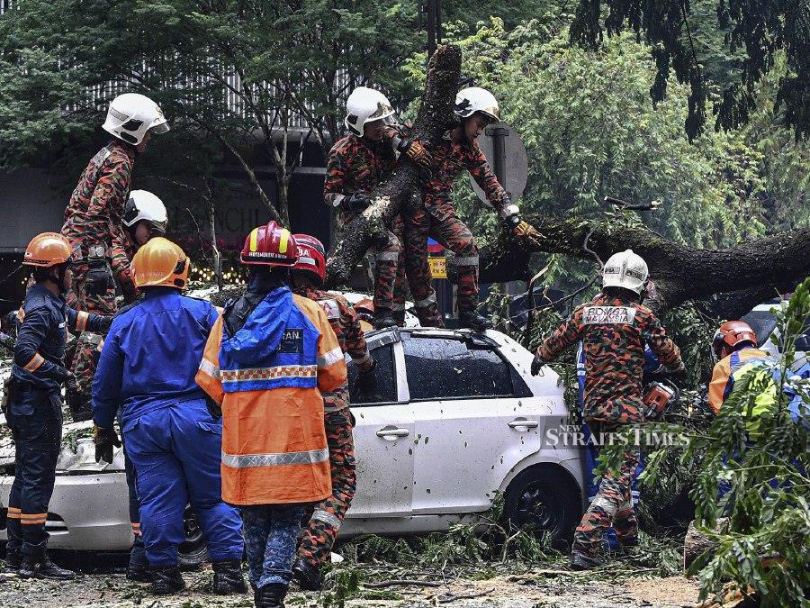 KUALA LUMPUR: Firefighters responding to the tree-falling incident are tirelessly working to clear the fallen tree, which damaged the monorail rail and crushed cars on Jalan Sultan Ismail. -BERNAMA PIC 