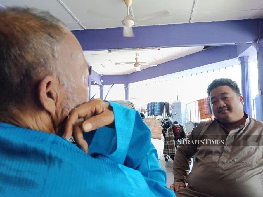Mohamad Fauzi Ramli, the manager of the Seri Permai Old Folks Home in Taman Tas, Kuantan, chats with Pok Yem, who was abandoned outside the home three weeks ago by his own child.NSTP/Asrol Awang