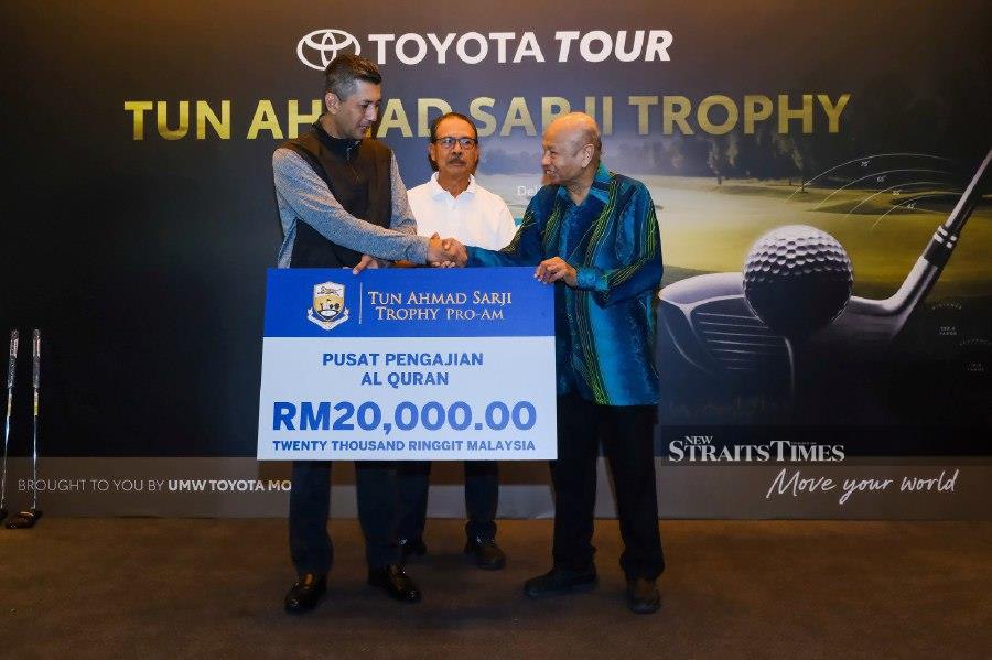 Ariff Tuah (left) handing over the cheque to Datuk Sulaiman Osman (right) as PGM general manager Nik Mustapha looks on.