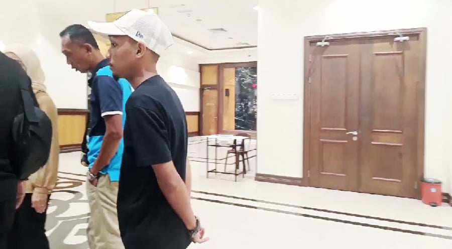 Lorry driver Mohammad Asraffi (wearing white cap), 21, was jailed for two days and fined RM10,000 in default of three months jail for offering a RM150 bribe to a policeman. — PIC COURTESY OF SABAH MACC