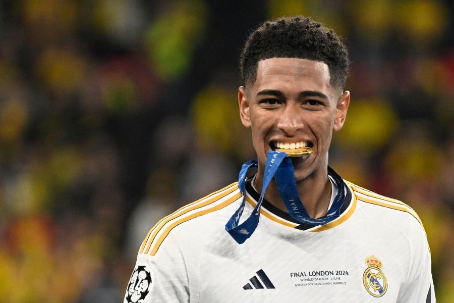 Real Madrid's English midfielder Jude Bellingham bites his gold medal after winning at the end of the UEFA Champions League final football match between Borussia Dortmund and Real Madrid, at Wembley stadium, in London. - AFP pic
