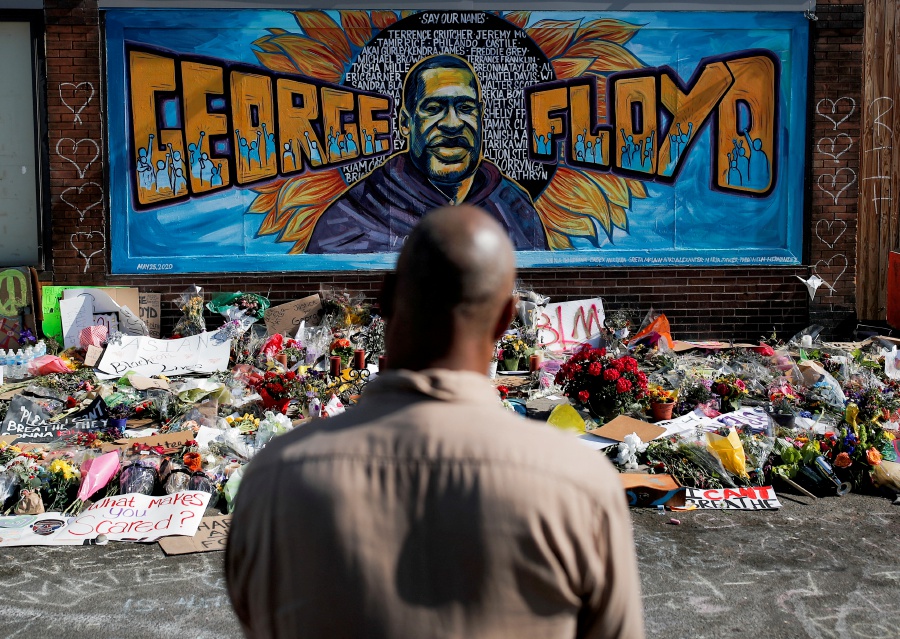 A local resident stands in front of a makeshift memorial honoring George Floyd, at the spot where he was taken into custody, in Minneapolis, Minnesota, US.- REUTERS Pic