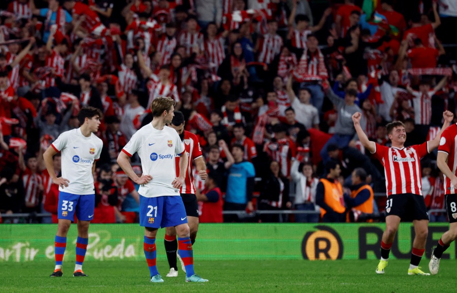 FC Barcelona's Frenkie de Jong and FC Barcelona's Pau Cubarsi look dejected as Athletic Bilbao's Aitor Paredes celebrates after the match. - REUTERS pic
