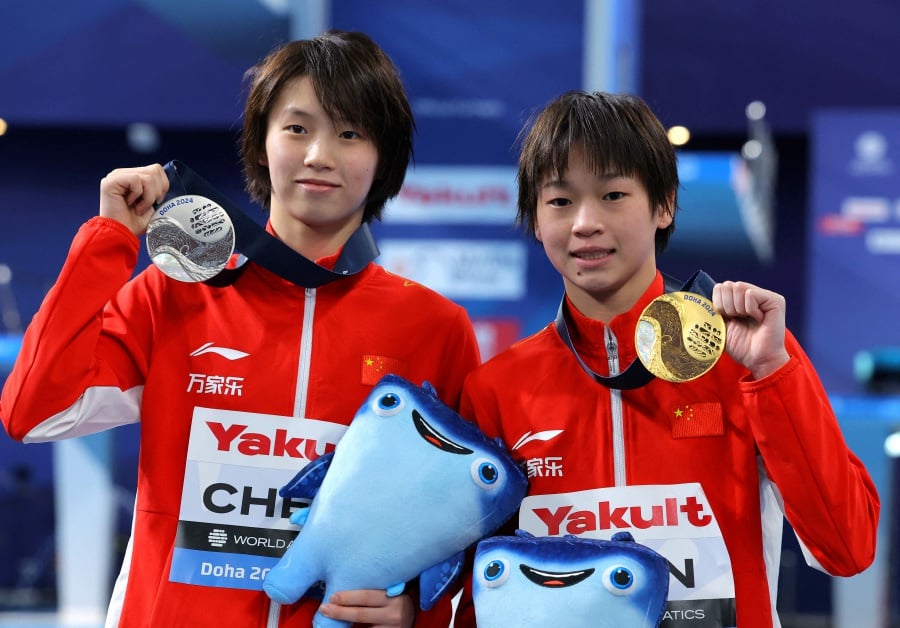 Gold medallist China's Hongchan Quan poses for a picture with her medal after winning the women's 10m platform final alongside silver medallist China's Yuxi Chen. - REUTERS pic
