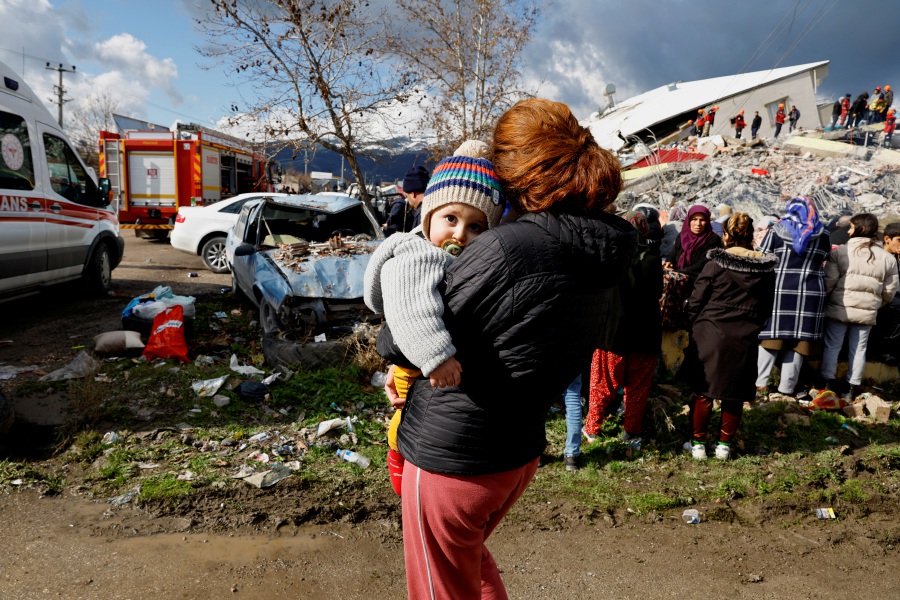 A woman holds a child as she stands near rubble and damages following an earthquake in Gaziantep, Turkey, February 7, 2023. - REUTERS Pic