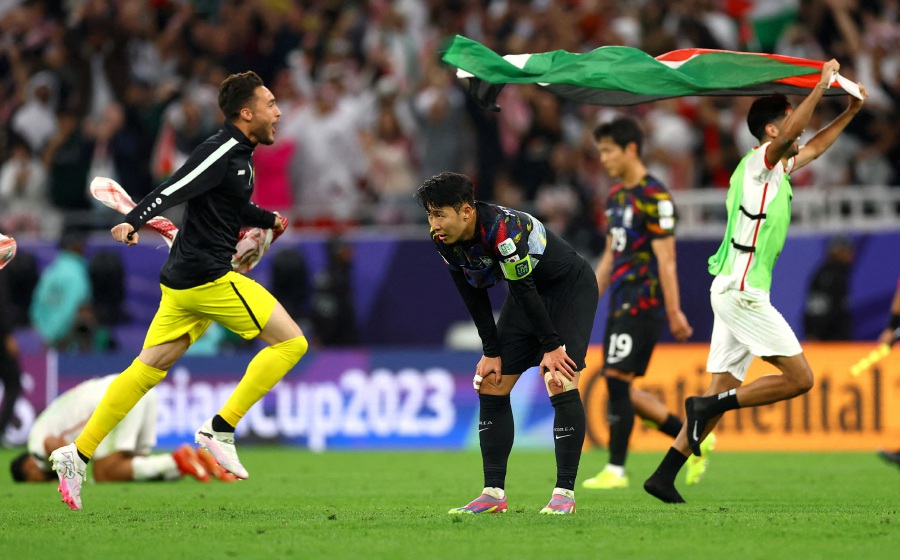 South Korea's Son Heung-Min looks dejected as Jordan players celebrate after reaching the AFC Asian Cup final. -REUTERS pic