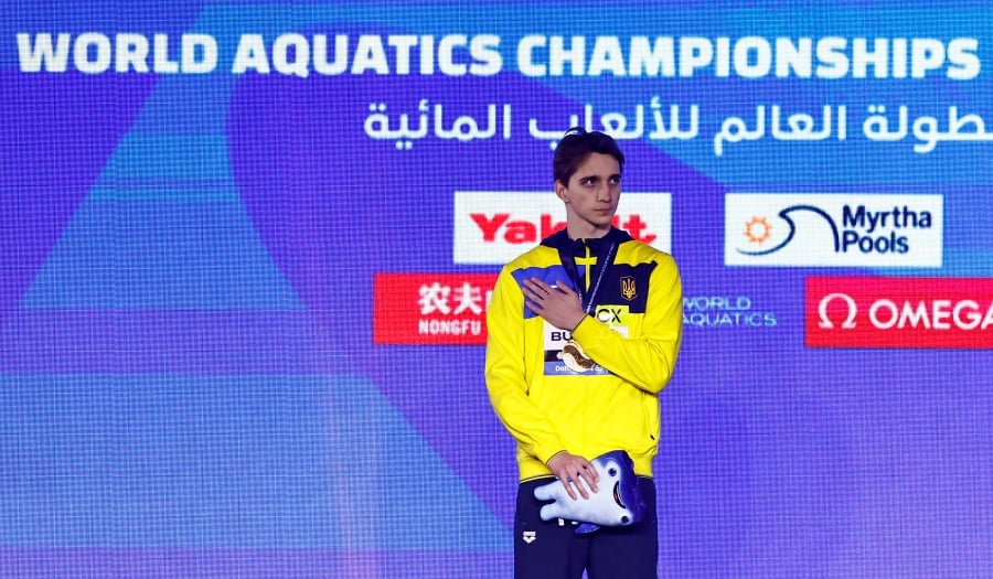 Gold medallist Ukraine's Vladyslav Bukhov celebrates on the podium during the men's 50m freestyle final medal ceremony. - REUTERS pic