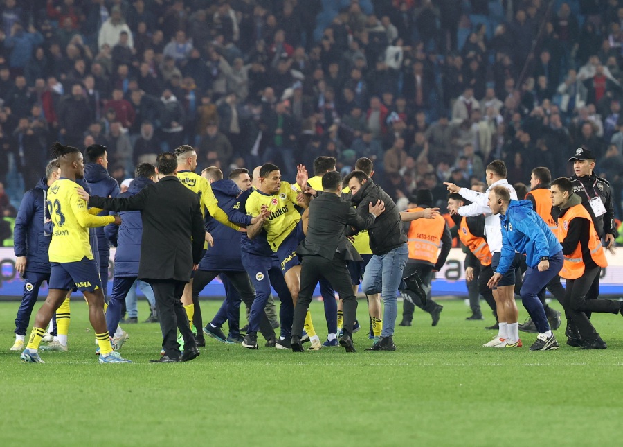 Trabzonspor fans invade the pitch and clash with Fenerbahce players and security staff after the match.-REUTERS pic