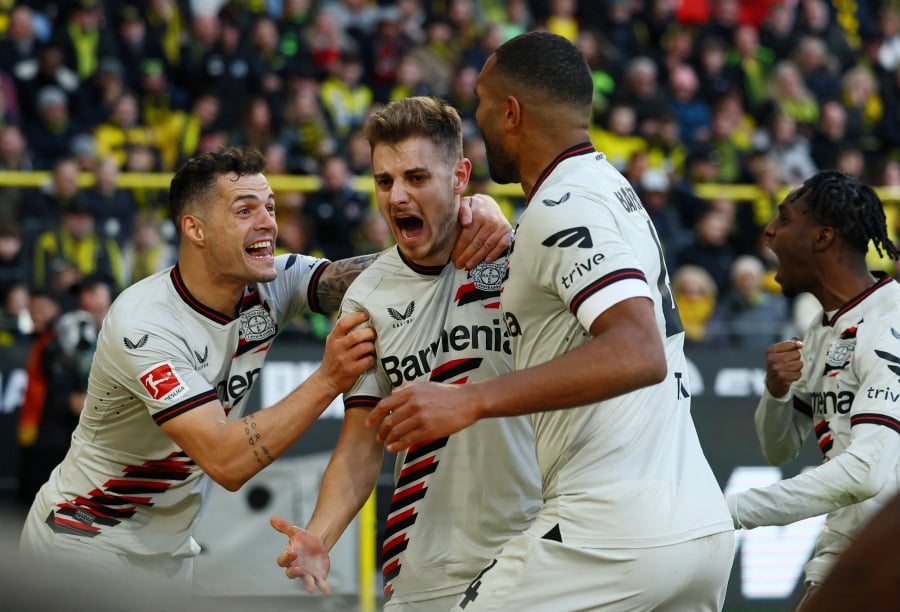 Bayer Leverkusen's Josip Stanisic celebrates scoring their first goal with Granit Xhaka and Jonathan Tah. - REUTERS PIC