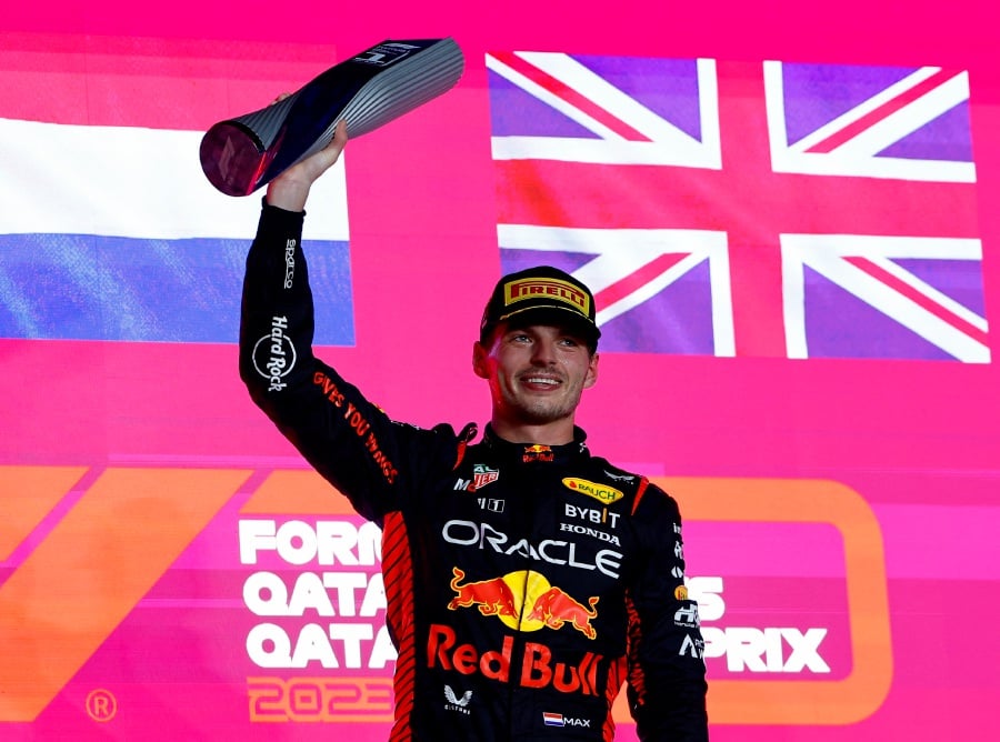 First placed Max Verstappen of Red Bull celebrates with his trophy on the podium after the race. - REUTERS Pic