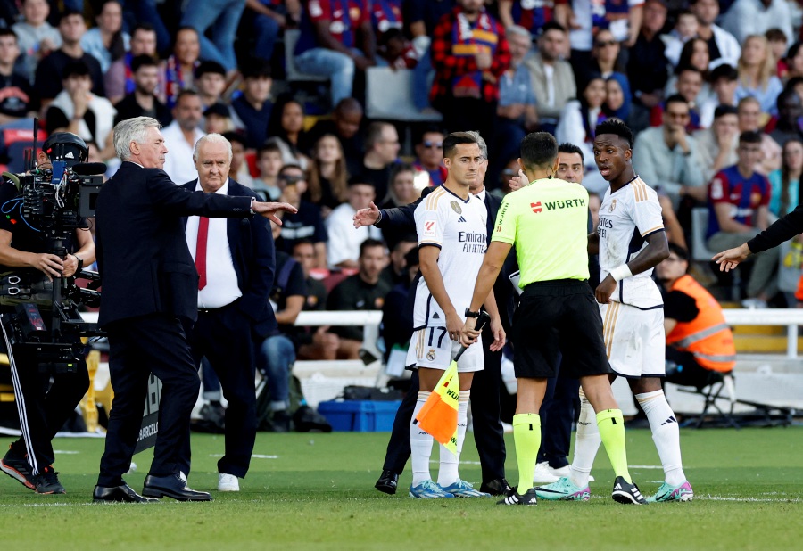 Real Madrid's Vinicius Junior is lead off the pitch by the referee assistant after been substituted as coach Carlo Ancelotti looks on. - REUTERS Pic