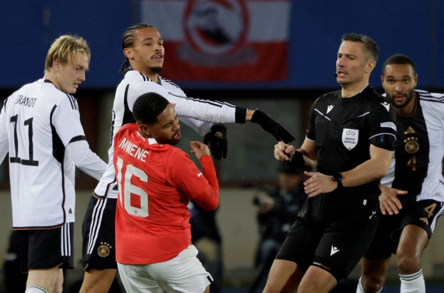 Germany's Leroy Sane clashes with Austria's Philip Mwene before he is shown a red card by referee Slavko Vincic. -REUTERS Pic