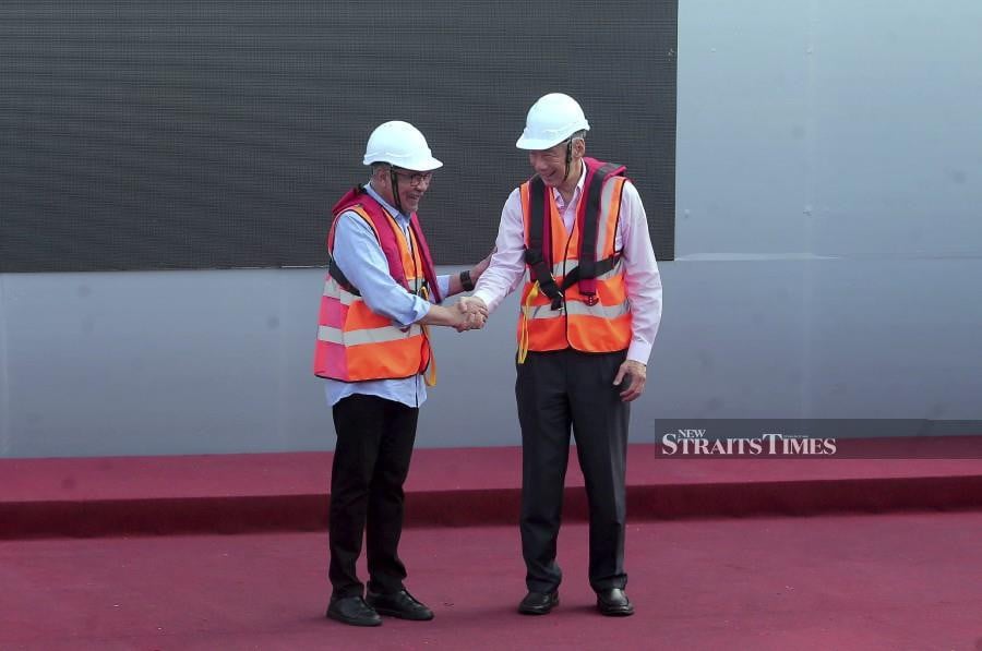 Prime Minister Datuk Seri Anwar Ibrahim shake hands with his Singaporean counterpart Lee Hsien Loong after the connection of the Johor Baru-Singapore Rapid Transit System (RTS) Link's span in Johor. - NSTP/NUR AISYAH MAZALAN