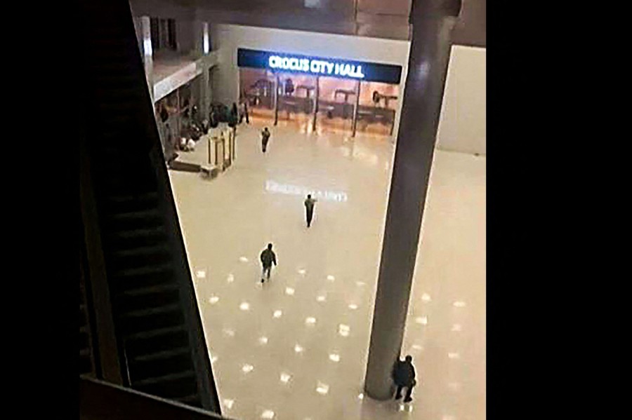 This image grab taken from footage obtained by AFP TV shows unidentified gunmen moving towards the doors of the Crocus City Hall in Krasnogorsk, outside Moscow, late on March 22, 2024. Camouflaged assailants opened fire at the packed Crocus City Hall in Moscow's northern suburb of Krasnogorsk on March 22, 2024, evening ahead of a concert by Soviet-era rock band Piknik in the deadliest attack in Russia for at least a decade. Russia on March 23, 2024, said it had arrested 11 people -- including four gunmen -- over the attack on a Moscow concert hall claimed by Islamic State, as the death toll rose to over 100 people. - (Photo by -UGC / UGC / AFP)