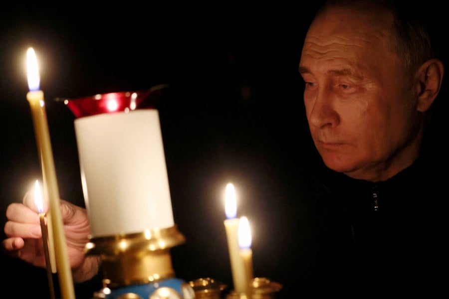 Russian President Vladimir Putin lights a candle in memory of the victims of the Crocus City Hall attack, on the day of national mourning in a church at the Novo-Ogaryovo state residence outside Moscow, Russia. - Sputnik/Mikhail Metzel/Pool via REUTERS