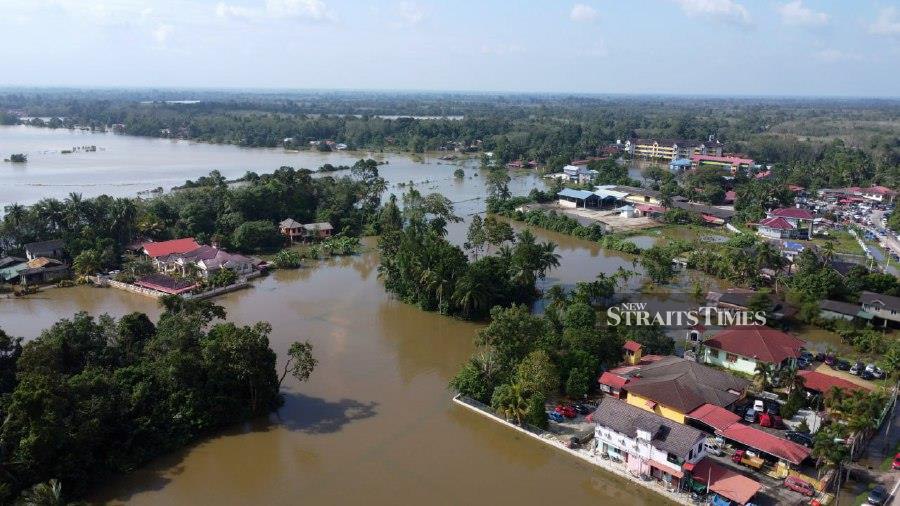Grappling with the aftermath of the third wave of floods that began three days ago, Rantau Panjang finds nearly 90 per cent of its area submerged. - NSTP/NIK ABDULLAH NIK OMAR