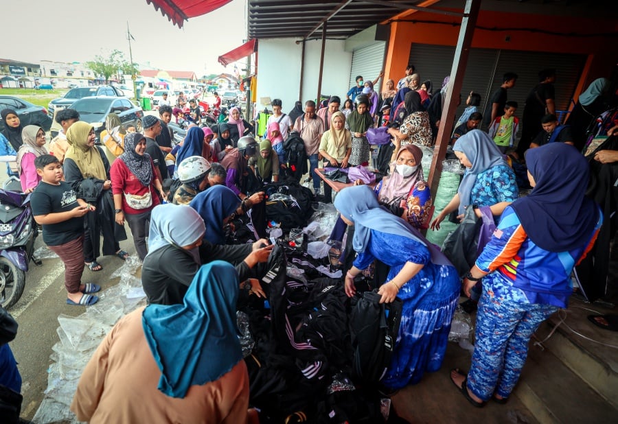 Traders at the Rantau Panjang duty-free zone here are auctioning off goods that were affected by flood waters at heavily discounted prices to cut losses. - Bernama pic
