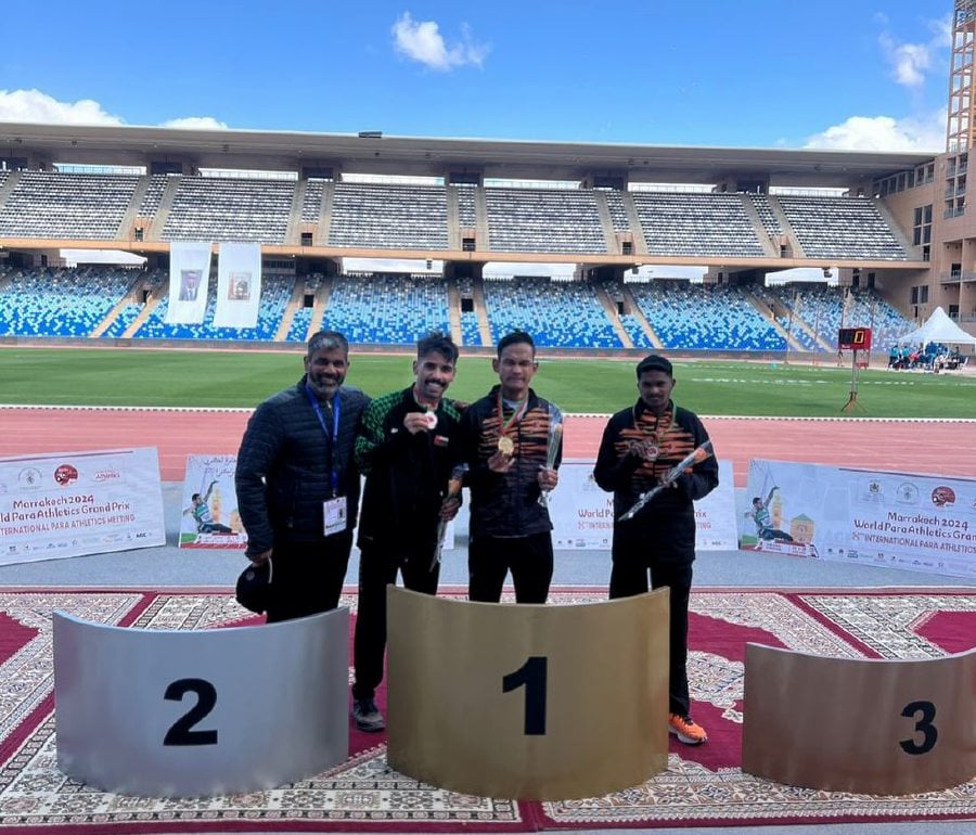Mohamad Ridzuan Mohamad Puzi (centre) pose with his gold medal after winning the men’s 100 metre (m) T35/36 (physical disability) race at the World Para Athletics Grand Prix in Marrakech, Morrocco. - Pic credit Facebook /majlissukannegaramalaysia
