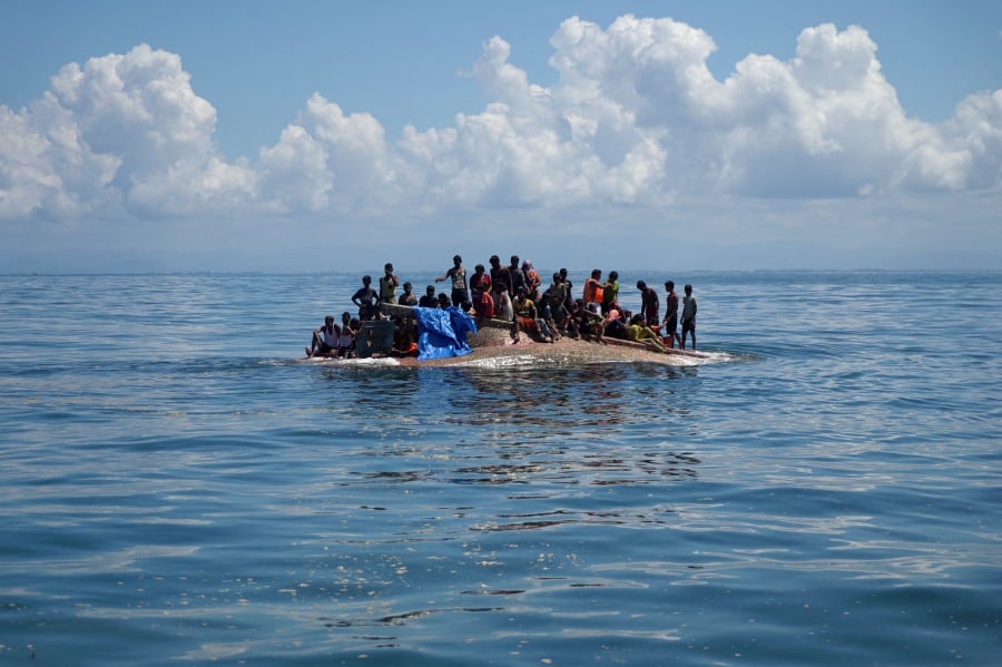 Rohingya refugees are seen on a capsized boat before being rescued in the waters of West Aceh, Indonesia. - Reuters pic