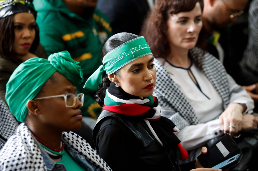 Pro-Palestinian supporters sit inside the Palestinian Embassy in Pretoria as they watch the International Court of Justice (ICJ) hearing of the case against Israel brought by South Africa. (Photo by Phill Magakoe / AFP)