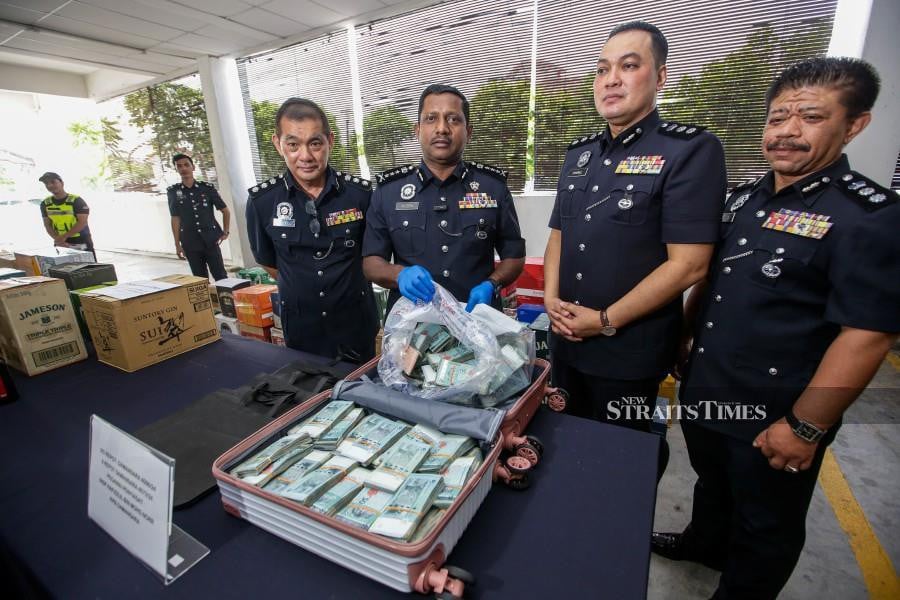 SUBANG JAYA: Selangor police chief Datuk Hussein Omar Khan (Second from left) together with his officers shows a bag filled with close to half a million Ringgit in cash that was found by a security guard in the parking lot of a shopping mall in Petaling Jaya, at the Subang Jaya district police headquarters. — STR / HAZREEN MOHAMAD
