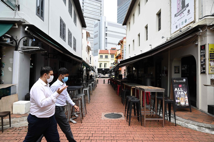 People walk past rows of restaurant along Boat Quay in Singapore on September 15, 2020.  - Singapore has preliminarily confirmed 27 new cases of Covid-19 infection in the past 24 hours, bringing the total tally for the republic to 57,515.(Photo by Roslan RAHMAN / AFP)