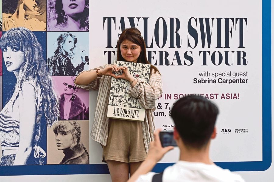 Fans of US singer Taylor Swift, also known as Swifties, take photos as they arrive for the pop star's Eras Tour concert at the National Stadium in Singapore. (Photo by Roslan RAHMAN / AFP)