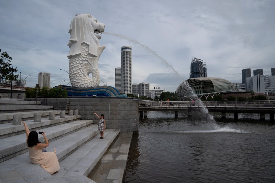 People pose for photos at the Merlion Park in Singapore, 23 November 2020. -  Singapore which reported a total Covid-19 infection  tally of 58,183 so far, has closed the last coronavirus cluster involving a migrant workers' dormitory, Tuesday.  EPA/HOW HWEE YOUNG
