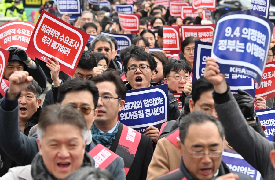 Doctors shout slogans with placards reading "Opposition to the increase in medical schools" as they march toward the Presidential Office during a rally to protest against the government’s plan to raise the annual enrolment quota at medical schools, in Seoul. (Photo by Jung Yeon-je / AFP)
