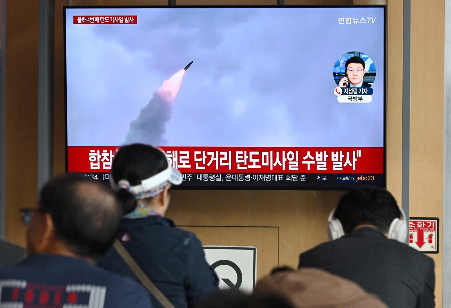 People watch a television screen showing a news broadcast with file footage of a North Korean missile test, at a railway station in Seoul. (Photo by Jung Yeon-je / AFP)