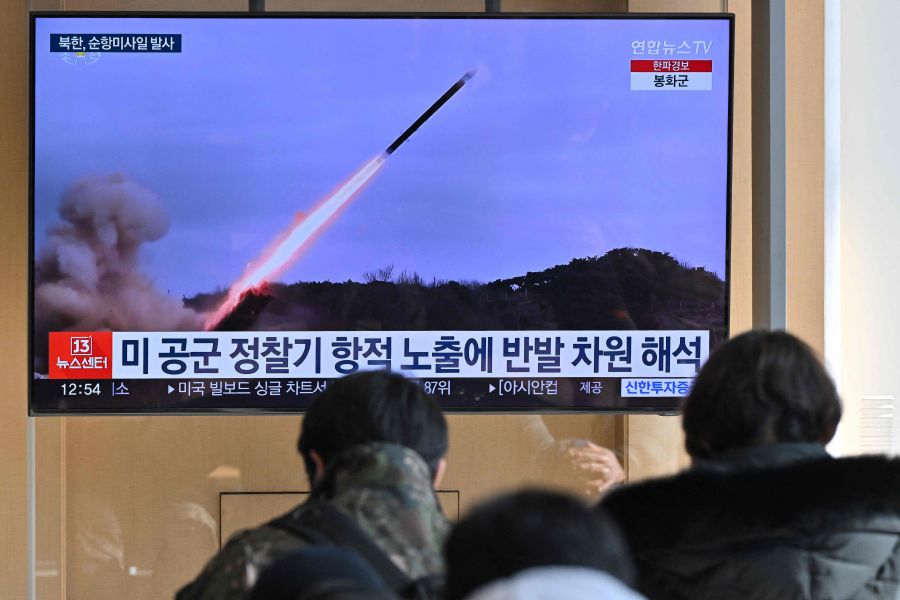 People watch a television screen showing a news broadcast with file footage of a North Korean missile test, at a railway station in Seoul.(Photo by Jung Yeon-je / AFP)