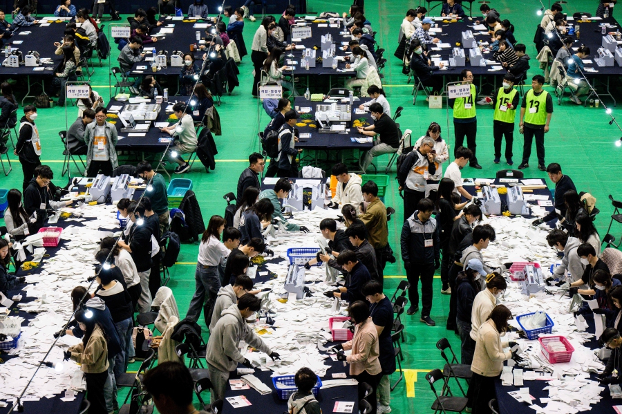 Election officials count ballots at a counting station in Seoul, after voting in the parliamentary elections was closed. (Photo by ANTHONY WALLACE / AFP)