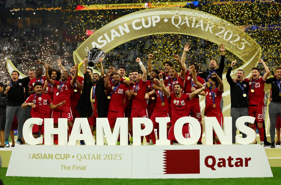 Qatar's Hassan Al-Haydos lifts the trophy with teammates after winning the AFC Asian Cup. REUTERS PIC