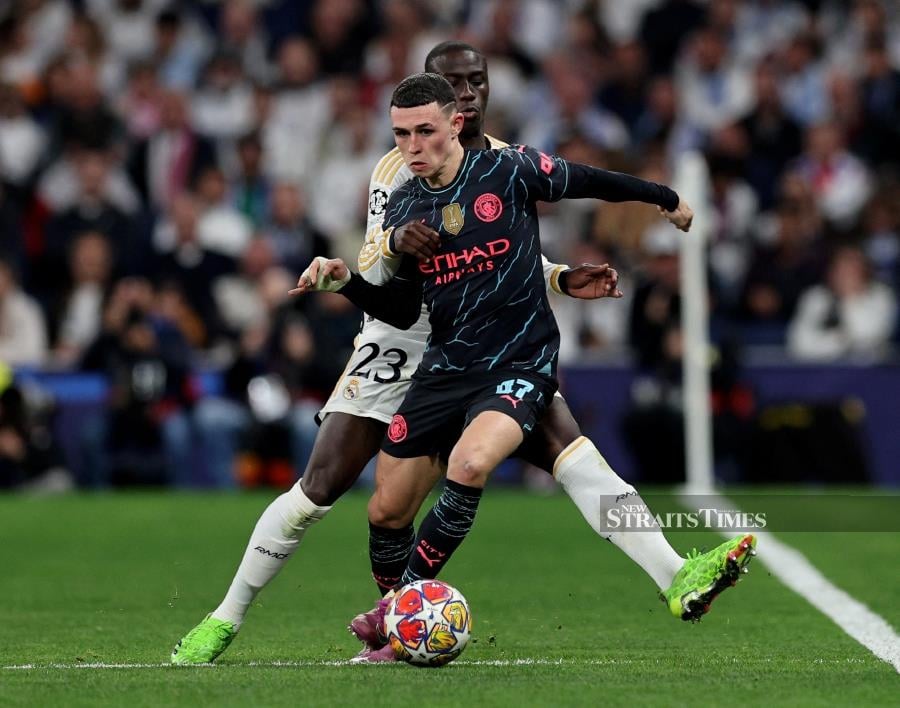 Real Madrid's Ferland Mendy in action with Manchester City's Phil Foden (front) in Tuesday’s Champions League quarter-final first leg at Santiago Bernabeu, Madrid, Spain. REUTERS PIC 