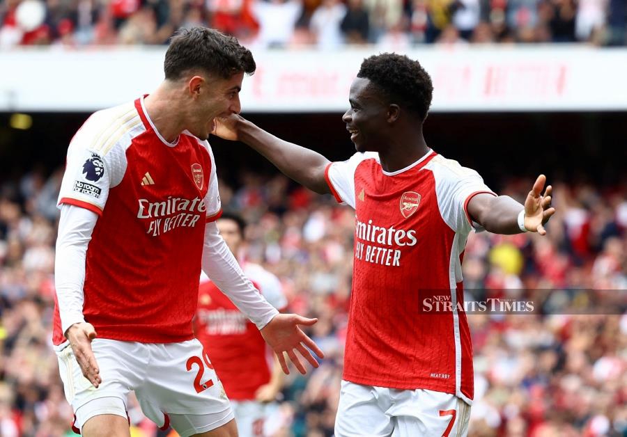 Arsenal's Bukayo Saka (right) celebrates scoring their first goal with Kai Havertz against Bournemouth in Saturday’s Premier League match at Emirates Stadium, London. REUTERS PIC 