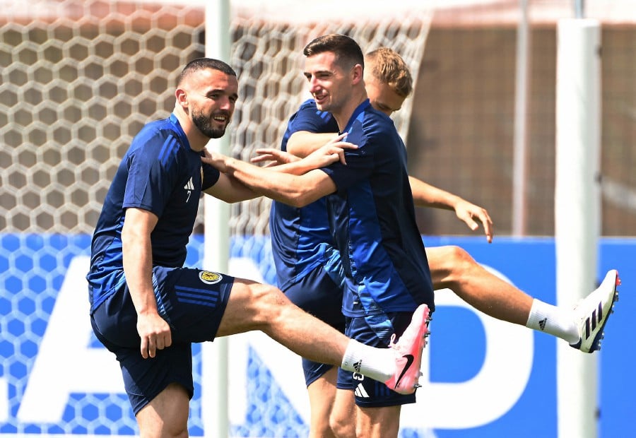 Scotland's John McGinn and Kenny McLean limbering up during training in preparation for their final Group A match against Hungary today (June 23). — REUTERS