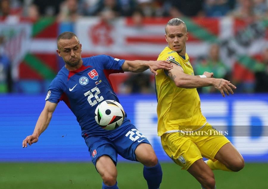 Slovakia's Stanislav Lobotka in action with Ukraine's Mykhailo Mudryk (right) during Friday’s Euro 2024 Group E match in Duesseldorf, Germany. REUTERS PIC 