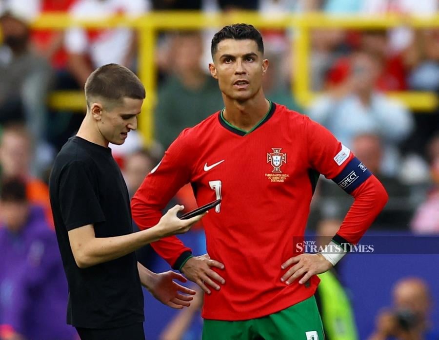 Pitch invader with Portugal's Cristiano Ronaldo before being detained by stewards during Saturday’s Euro 2024 Group F match against Turkiye at Dortmund BVB Stadion, Dortmund, Germany. REUTERS PIC