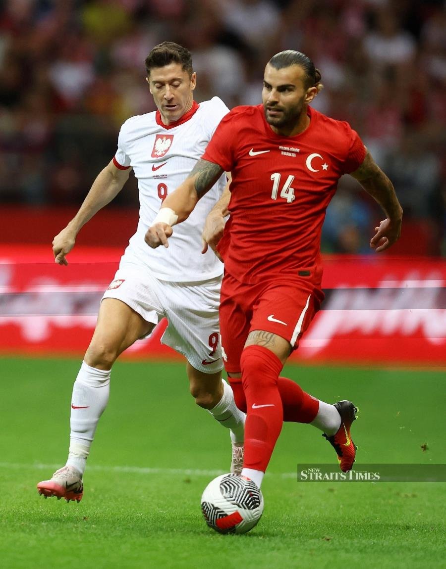 Turkey's Abdulkerim Bardakci (right) in action with Poland's Robert Lewandowski in a friendly at National Stadium, Warsaw, on Monday. REUTERS PIC