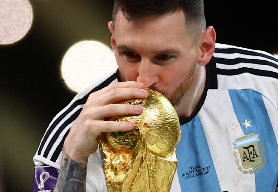 Argentina's Lionel Messi kisses the trophy as he celebrates winning the World Cup. (REUTERS/Carl Recine)