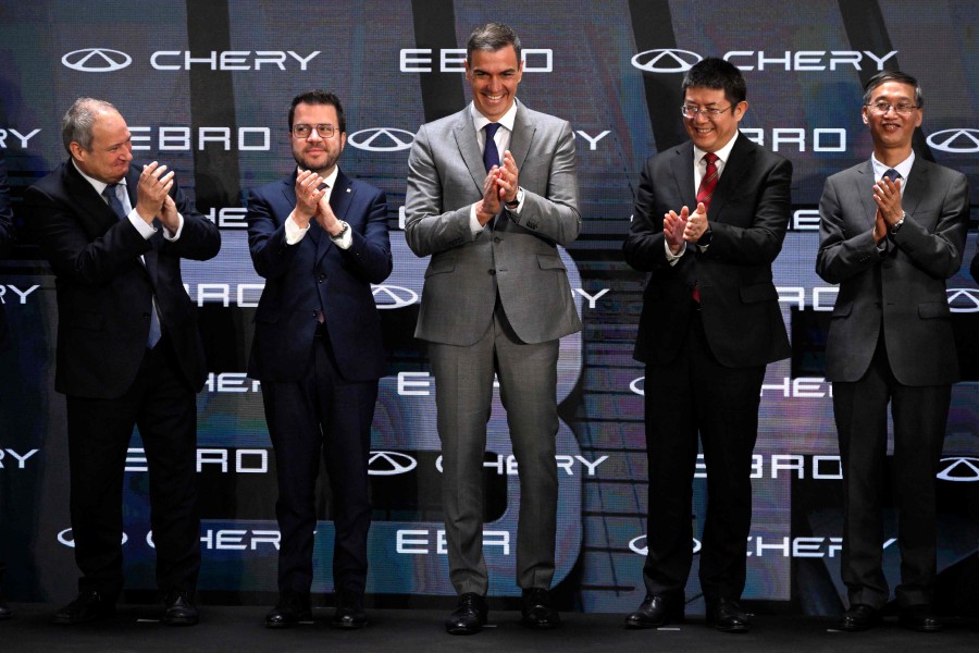 Spanish Prime Minister Pedro Sanchez (C) and Catalan regional President Pere Aragonez (2L) applaud following the signing of a joint venture agreement between Ebro-EV Motors and Chinese carmaker Chery at the former Nissan factory in Barcelona. -- AFP photo