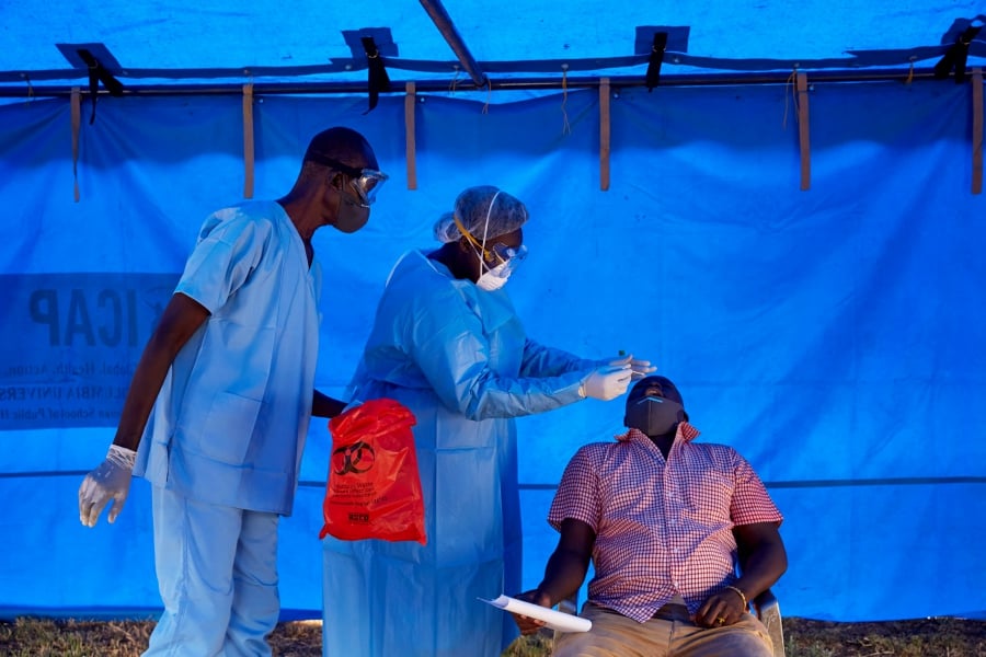 Members of South Sudanese Ministry of Health's Rapid Response Team take a sample from a man who has recently been in contact with a confirmed case of the COVID-19 coronavirus in Juba, South Sudan, on April 13, 2020. - Four cases of the COVID-19 coronavirus have been confirmed among United Nations (UN) national and international staff in South Sudan. (Photo by Alex McBride / AFP)