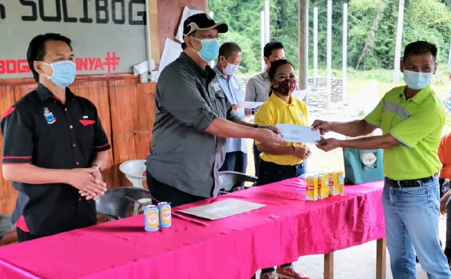 Sabah Tourism, Culture and Environment Assistant Minister cum Sabah Tourism Board (STB) chairman Datuk Joniston Bangkuai (second from left) presenting Sabah New Deal special grant to one of the rural tourism operators at Kampung Solibog in Tambunan. - Photo courtesy of STB