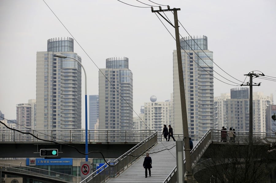 FILE PHOTO: People walk on a bridge near the district of Pudong in Shanghai, China, March 29, 2016. REUTERS/Aly Song/File Photo