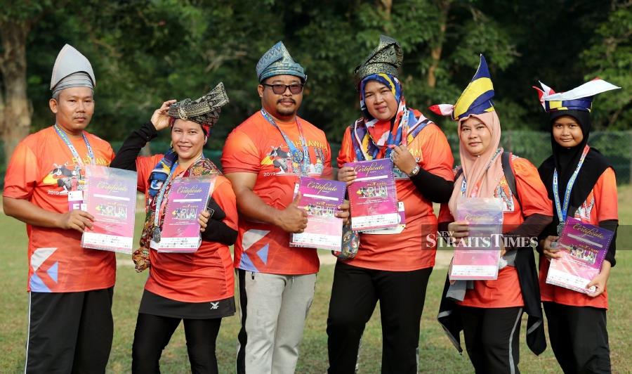Also attracting the crowd’s attention was Saedon Abu Bakar (3rd from left) , 37, who arrived at the college ground with six family members, wearing the tanjak nicknamed 'Dendam Tak Sudah'. - NSTP/RASUL AZLI SAMAD