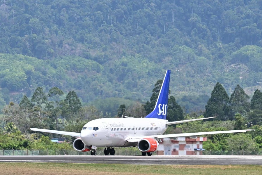 A Scandinavian Airlines (SAS) Boeing 737-700 aircraft believed to carry Norway's King Harald V prepares for take-off on the runway at Langkawi International Airport. -- AFP