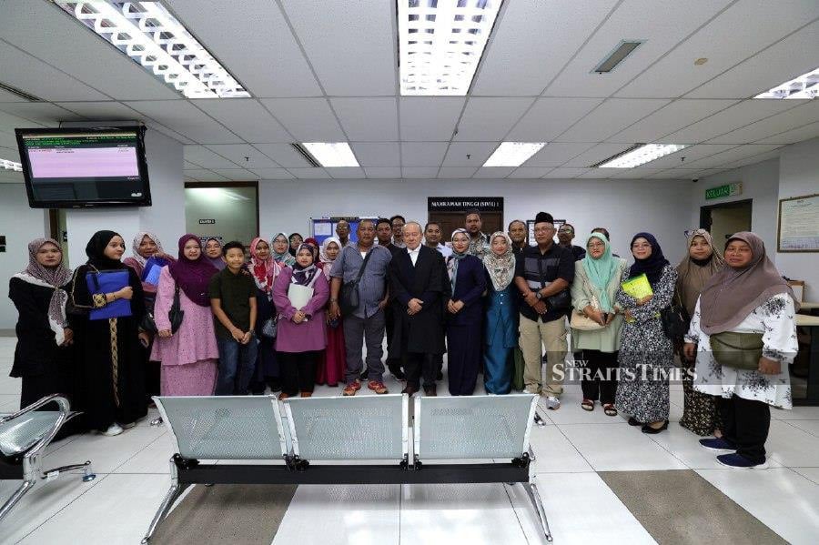 Lawyer Datuk Kamaruddin Ahmad (centre) with the victim's family after the civil proceeding of the lawsuit at the High Court in Johor. -- NSTP/NUR AISYAH MAZALAN 